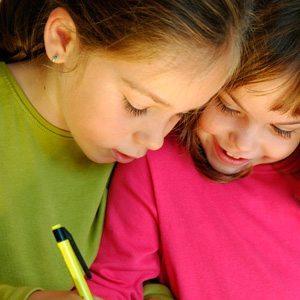 Two young autistic girls helping each other out